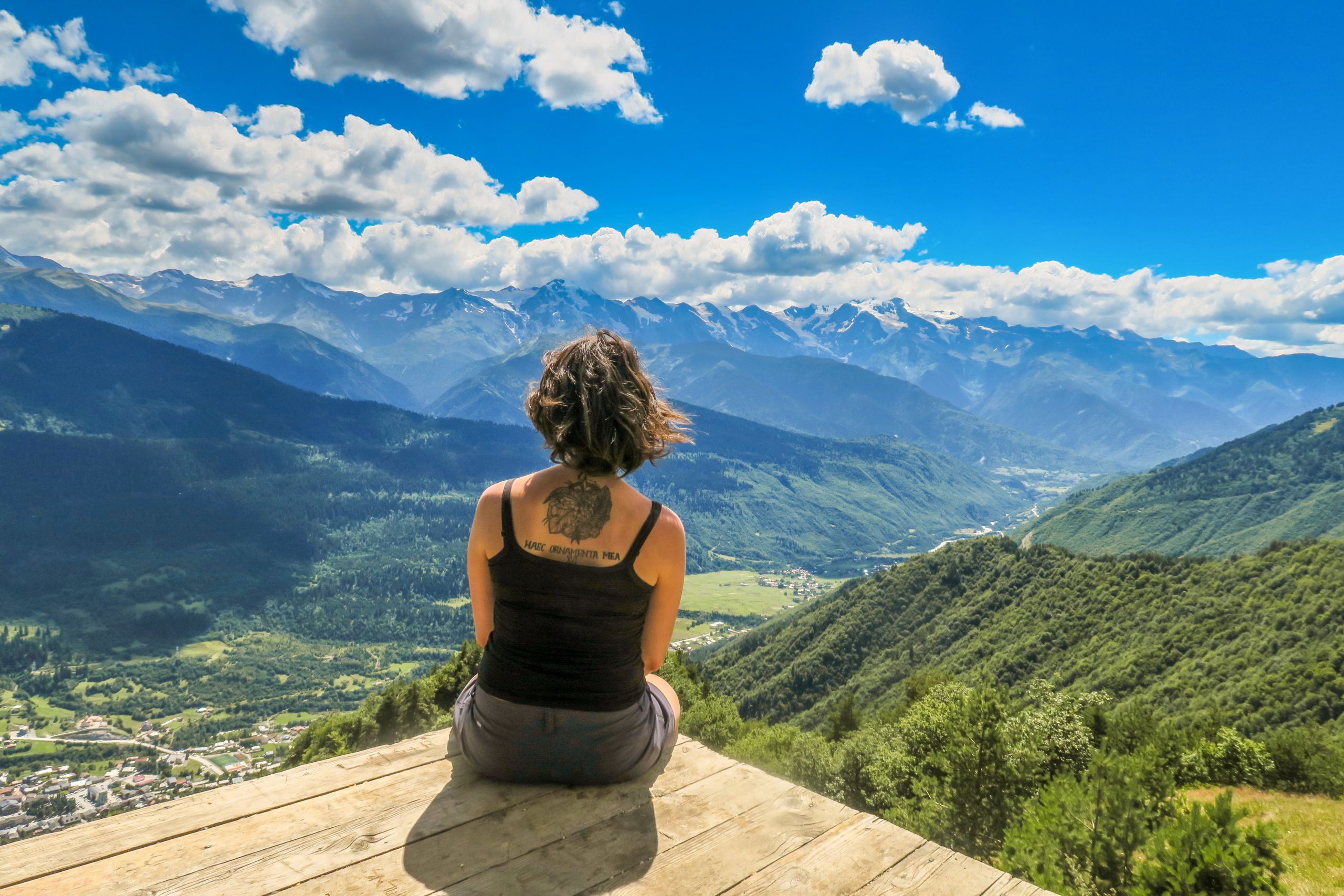 Donna seduta su un belvedere con vista sulle montagne in Georgia.